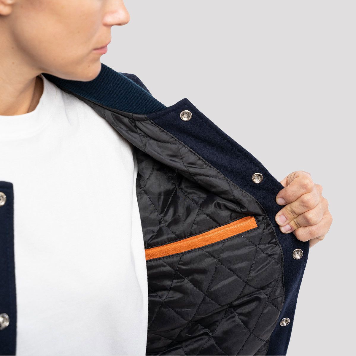 Trendy royal blue wool letterman jacket featuring orange leather sleeves, ideal for adding a pop of color to any outfit