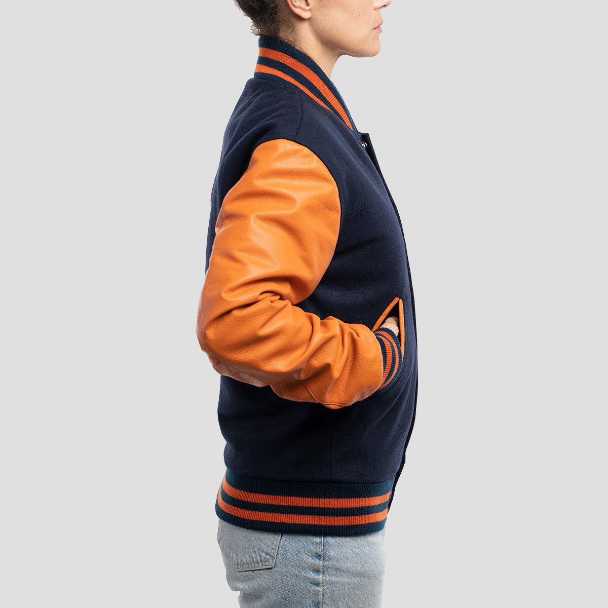 Stylish royal blue wool letterman jacket accented with bright orange leather sleeves, perfect for making a statement.