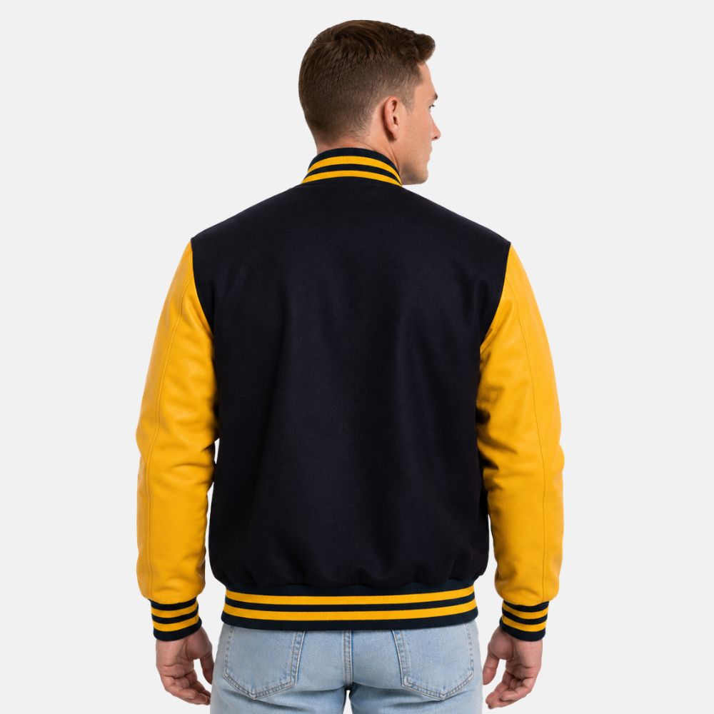 Back view of navy blue wool varsity jacket featuring lemon leather sleeves and striped ribbed waistband and cuffs.