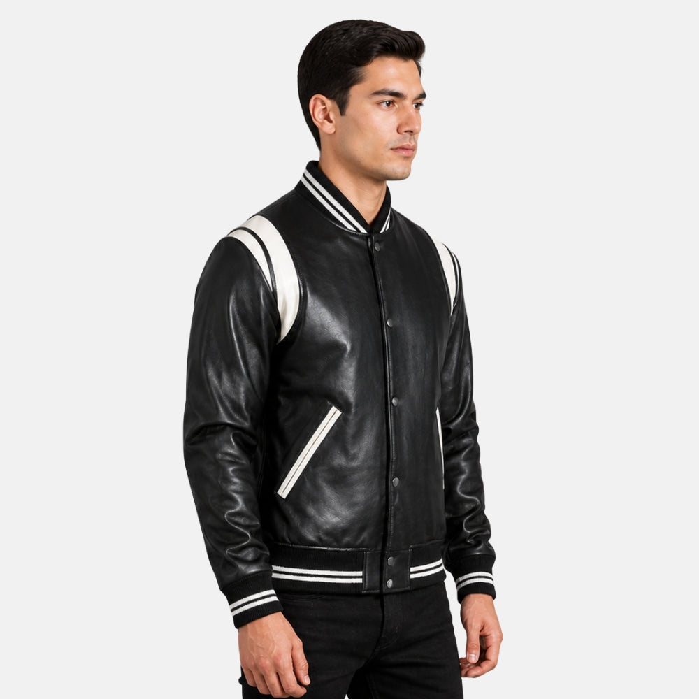 Man wearing a black leather varsity jacket with white accents on a light gray background