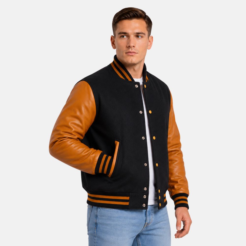 Men’s black and gold letterman jacket with premium wool body and gold leather sleeves on a gray background.