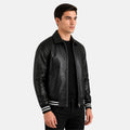 Man wearing a black leather jacket with white stripes on a gray background