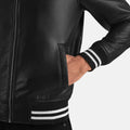 Black leather jacket with white stripes on cuffs and waistband against a light gray background