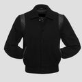 A vintage black wool college jacket with leather sleeves and snap button closure.
