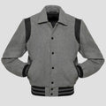 A grey wool letterman-style jacket with black leather sleeves and rib-knit trim on the collar, cuffs, and hem, featuring a snap button closure.