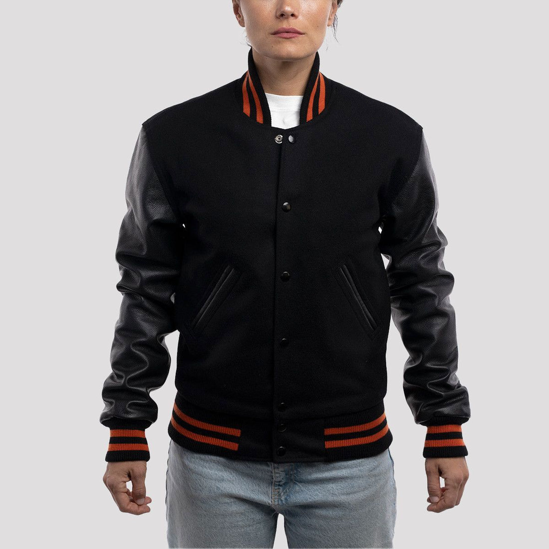 Sleek black body varsity jacket with bright orange stripes on the cuffs and collar, offering a bold and sporty look