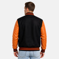 Man wearing a black and orange varsity jacket on a white background