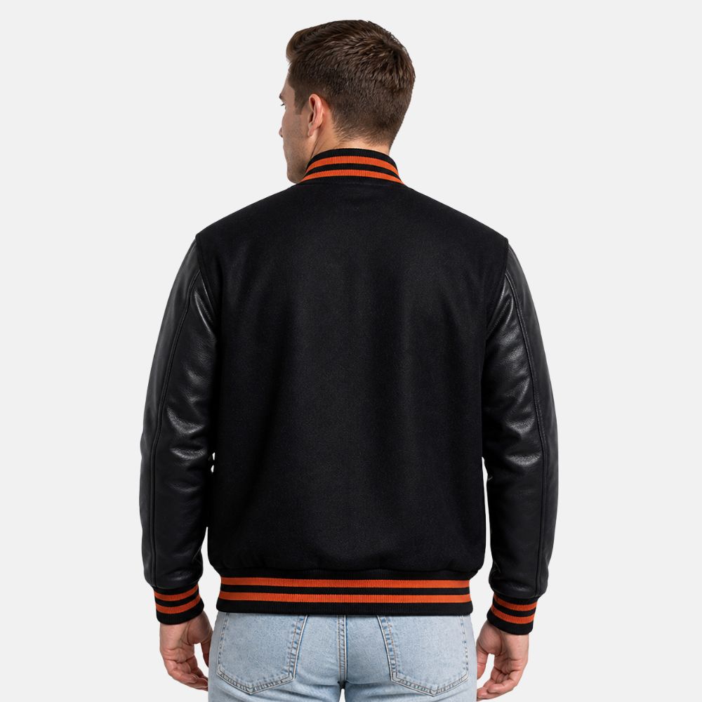 Man wearing a black varsity jacket with leather sleeves on a white background