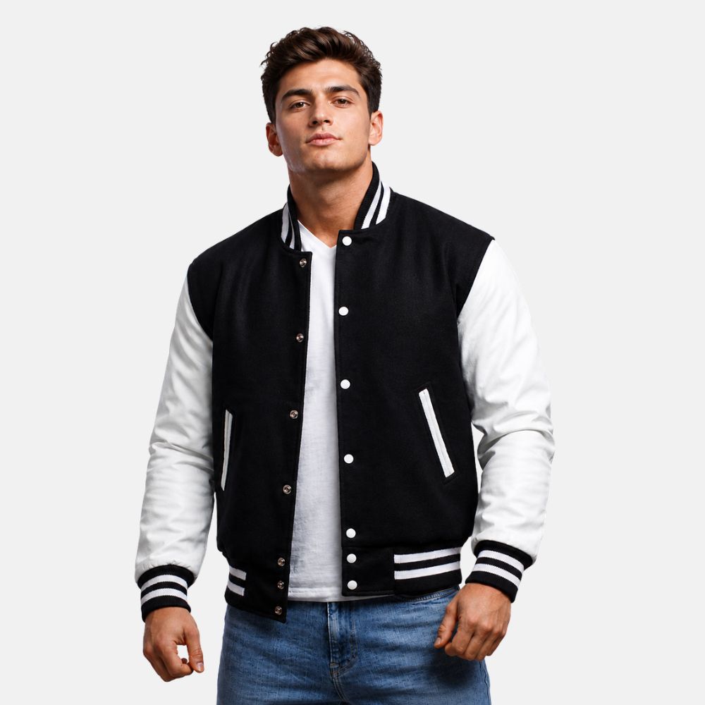 Man wearing a black and white varsity jacket on a plain background