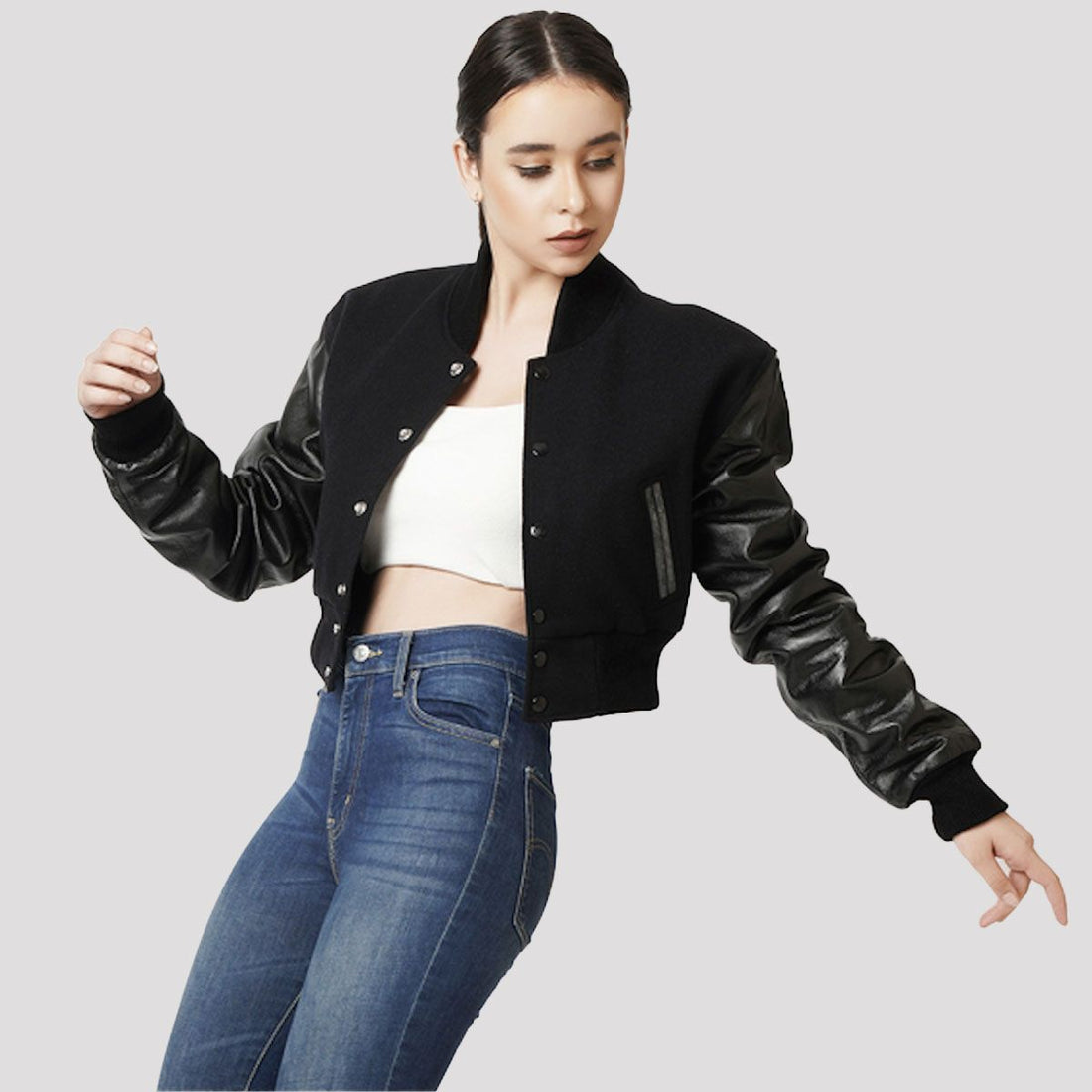 Trendy black wool and leather letterman crop top jacket, combining sporty varsity style with a modern cropped silhouette.