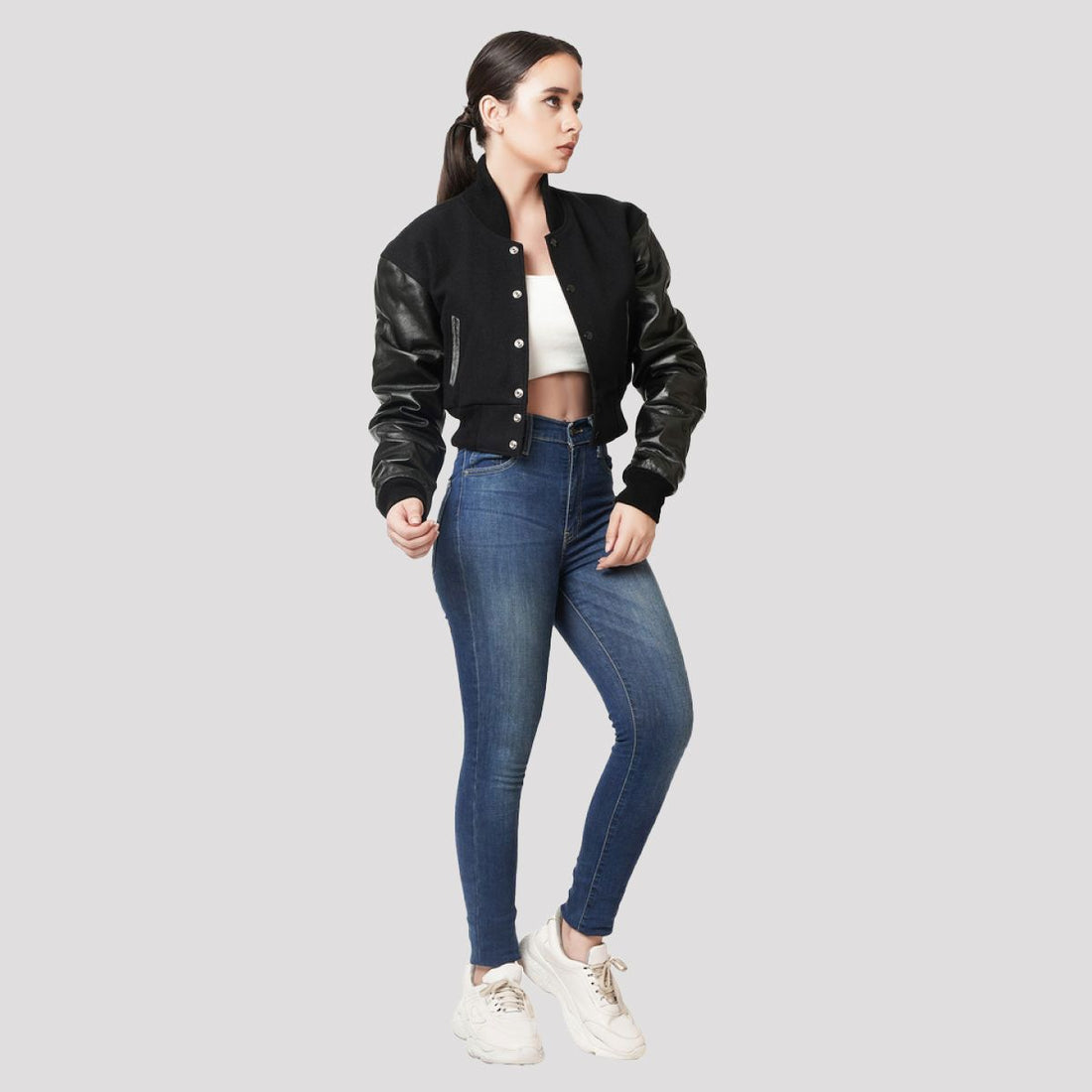 Trendy black wool and leather letterman crop top jacket, combining sporty varsity style with a modern cropped silhouette.