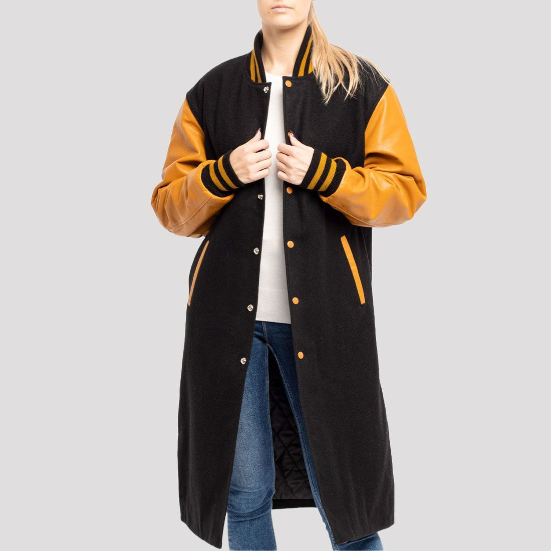 Classic black wool letterman coat with old gold leather sleeves, combining timeless varsity style with a luxurious finish