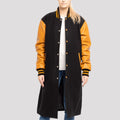 Women's black wool letterman coat with contrasting old gold leather sleeves, blending sporty and sophisticated styles