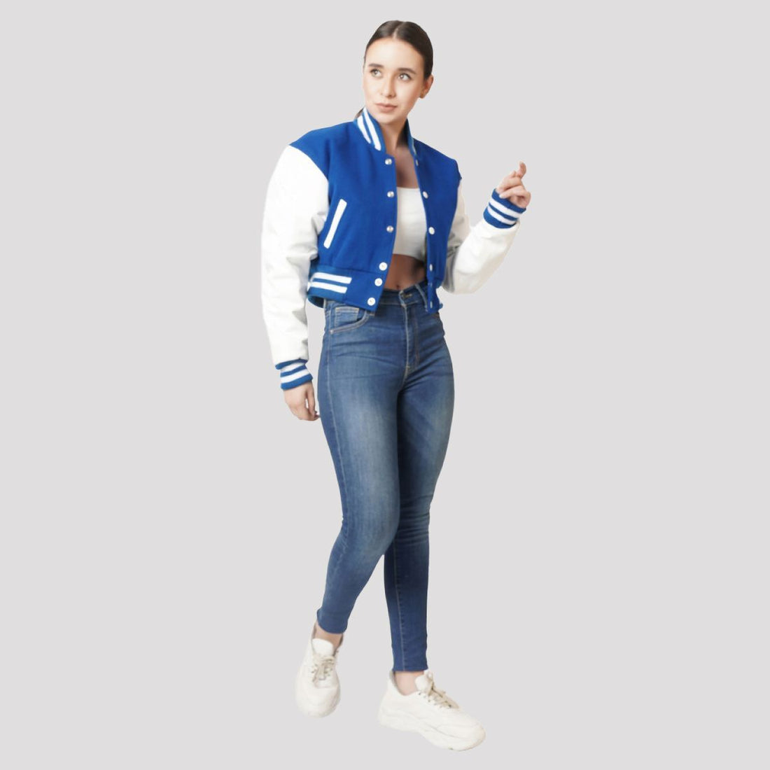 Trendy bright royal blue crop top varsity jacket with contrasting white sleeves, offering a modern twist on a classic style.