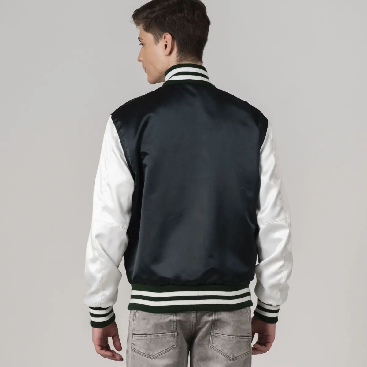 Trendy forest green satin varsity jacket featuring white sleeves, combining elegance and athletic appeal.