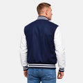 Man wearing a navy and white varsity jacket on a plain background