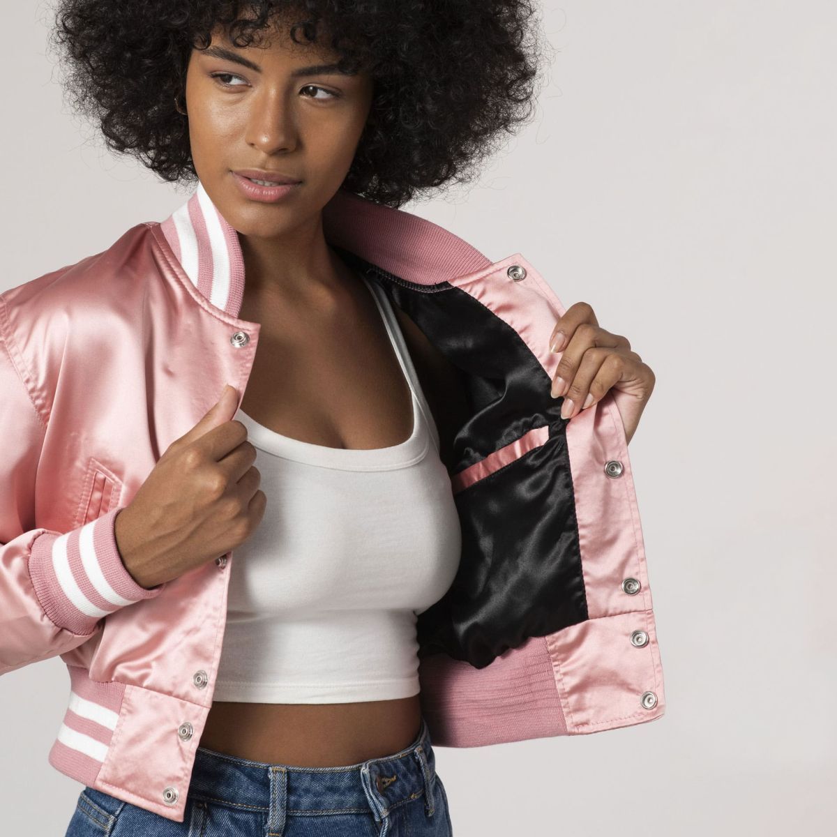 Chic pink satin varsity jacket with a cropped design, perfect for adding a pop of color to any outfit.