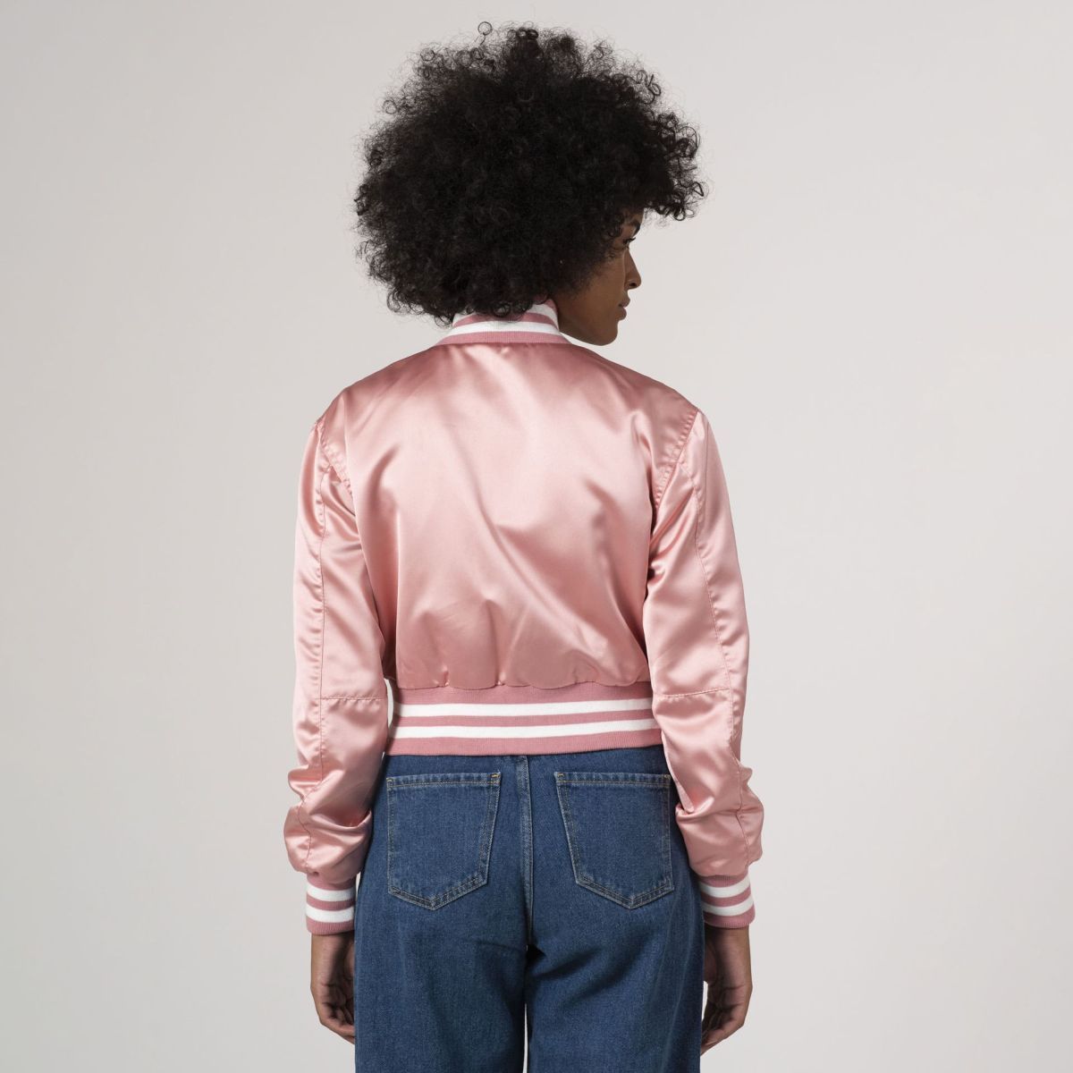 Stylish pink satin crop top varsity jacket, blending sporty elements with a feminine touch.