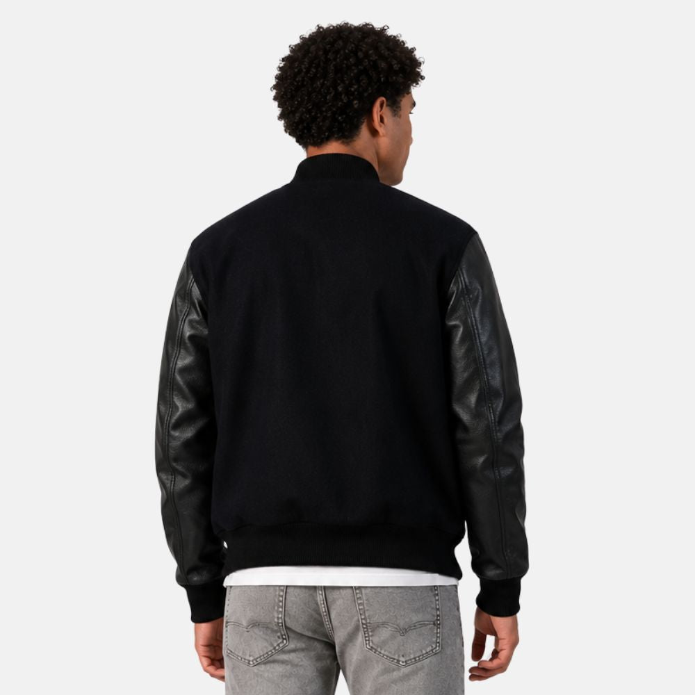 Person wearing a black bomber jacket with leather sleeves on a white background