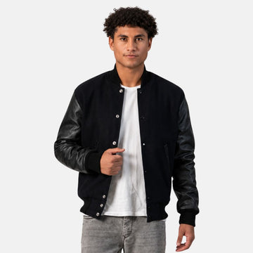 Person wearing a black leather jacket over a white shirt on a plain background