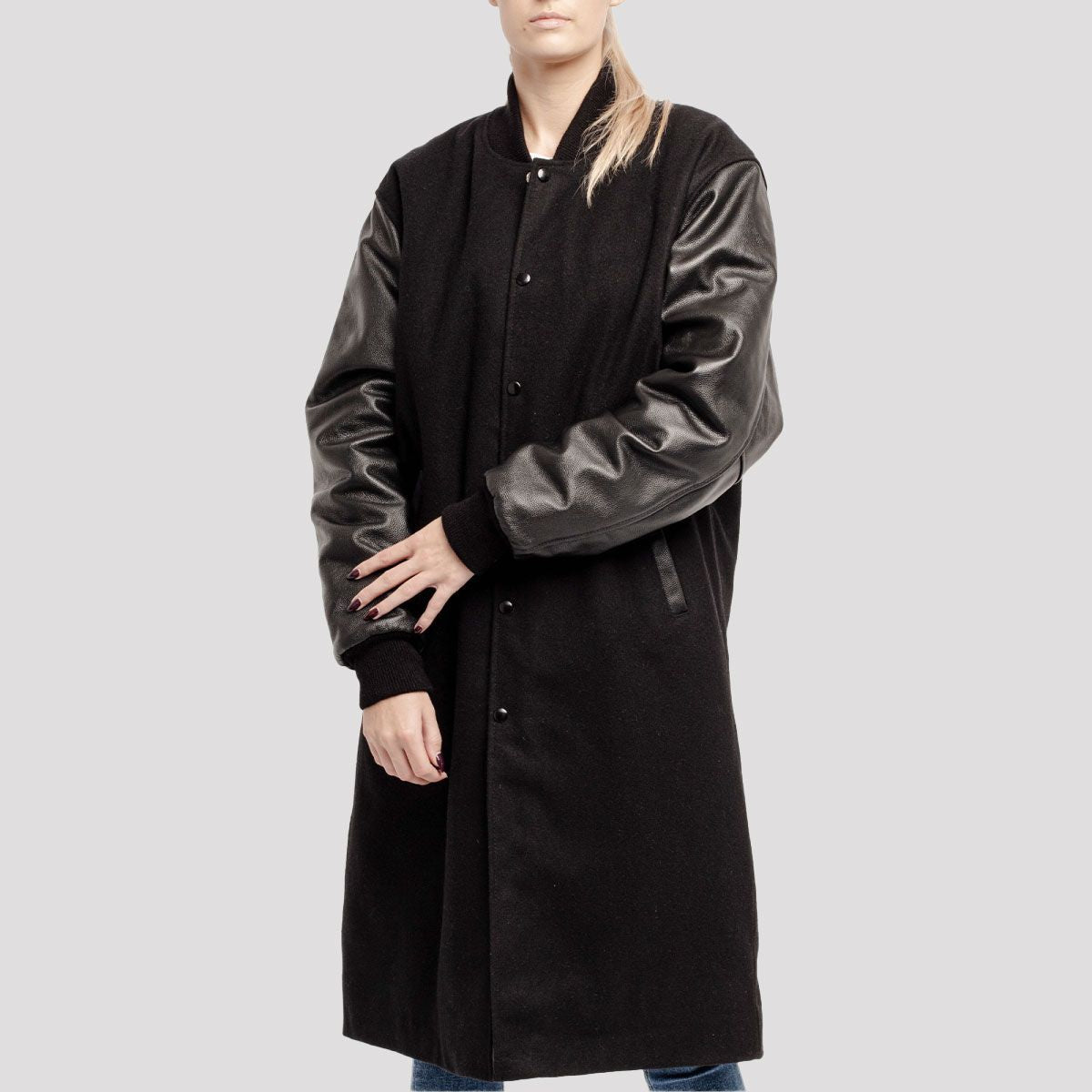 Women's black wool varsity coat featuring luxurious leather sleeves for an elegant, athletic look