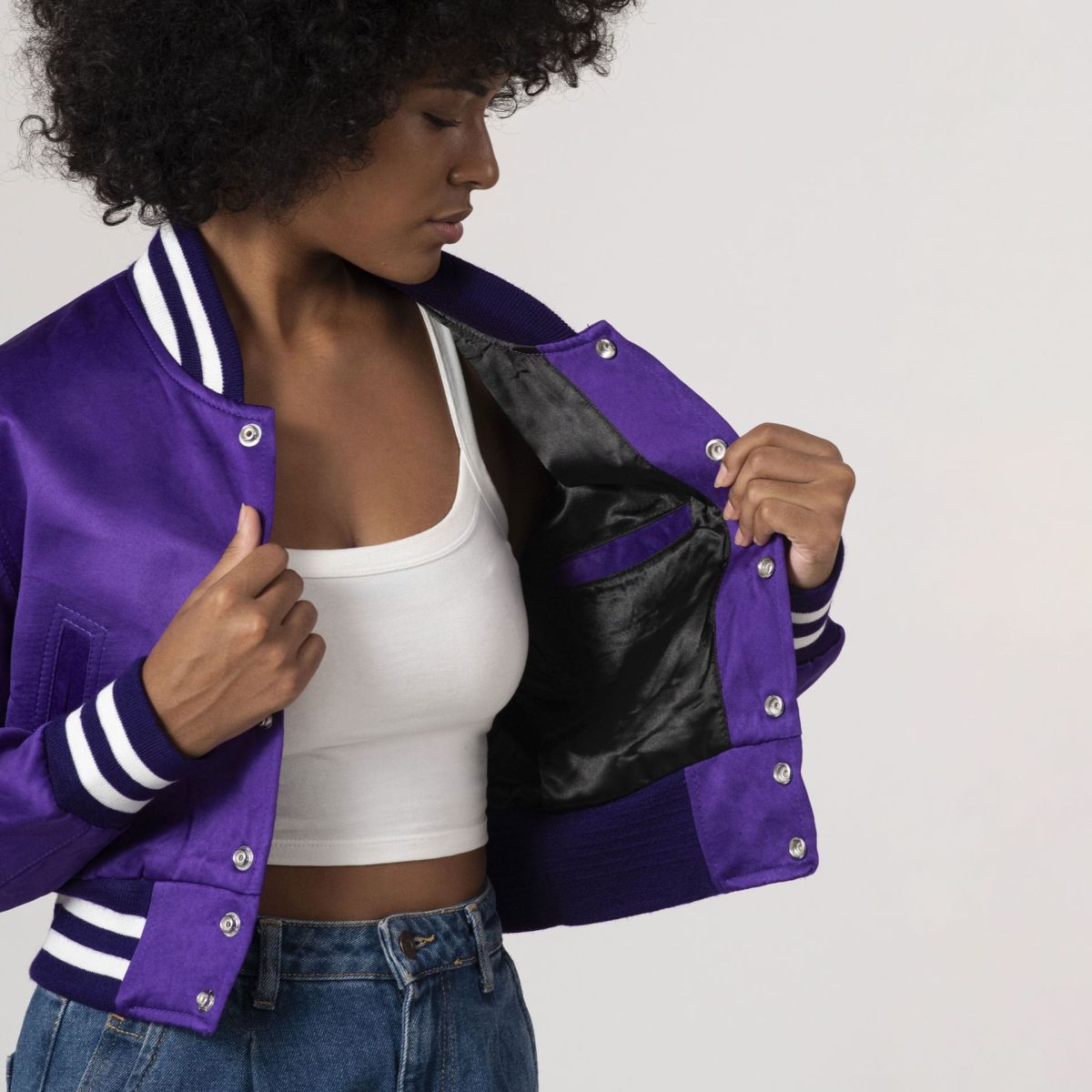 Women's purple satin varsity jacket with a cropped silhouette, great for layering with casual styles