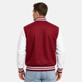 Man wearing a red and white varsity jacket on a plain background