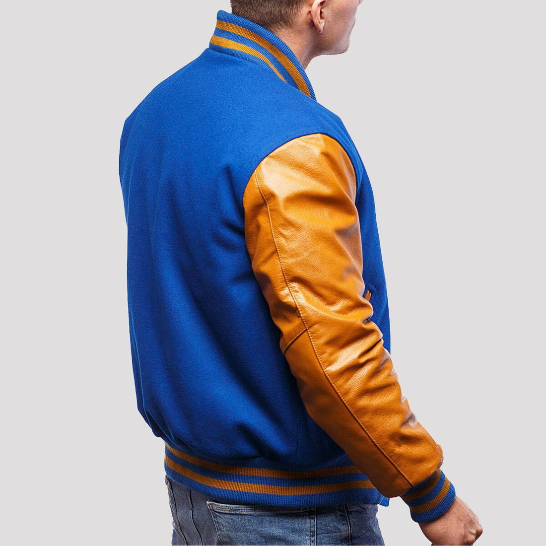 Stylish royal blue wool letterman jacket accented with gold leather sleeves, ideal for making a fashion statement