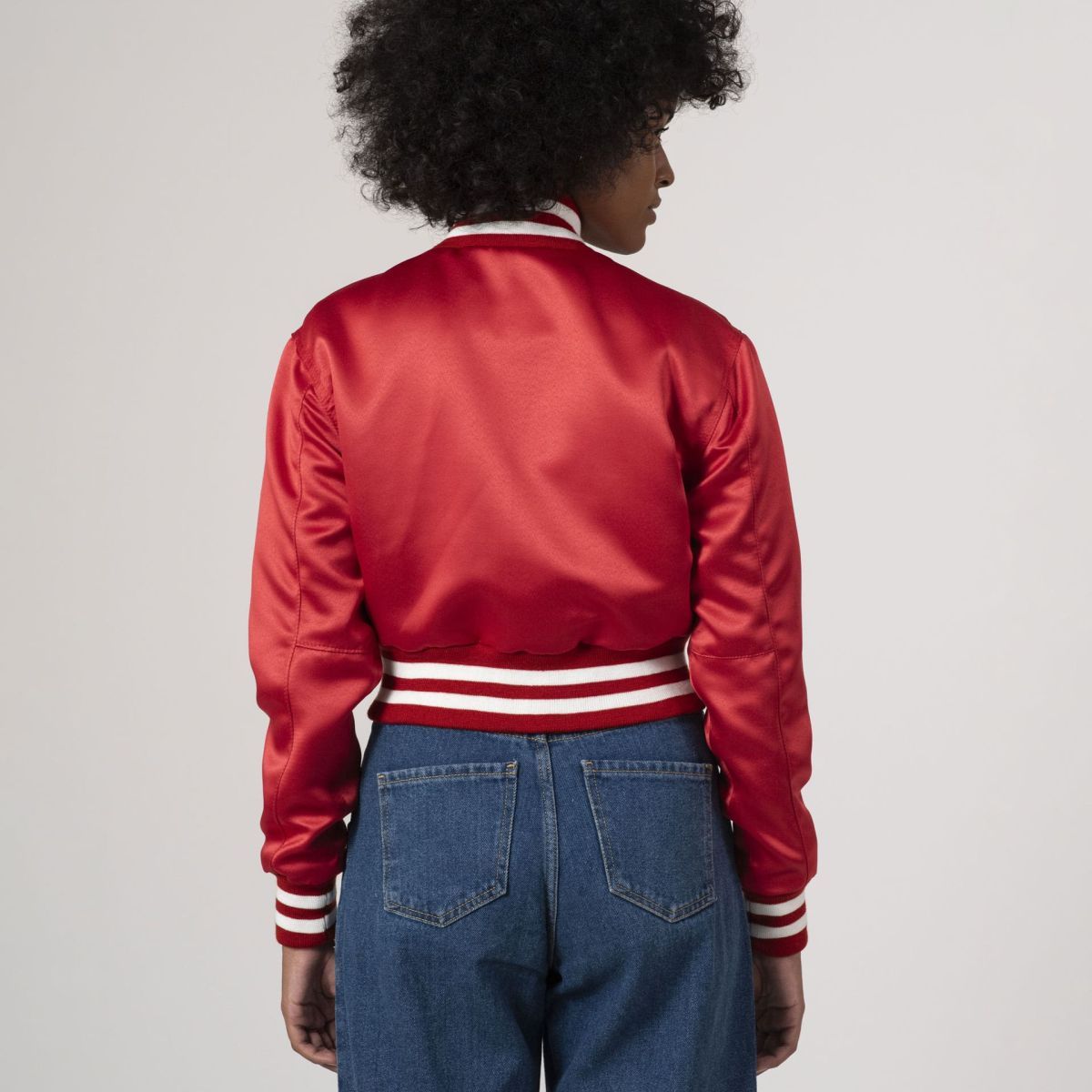 Stylish scarlet red satin crop top varsity jacket, offering a bold pop of color for any fashion-forward wardrobe