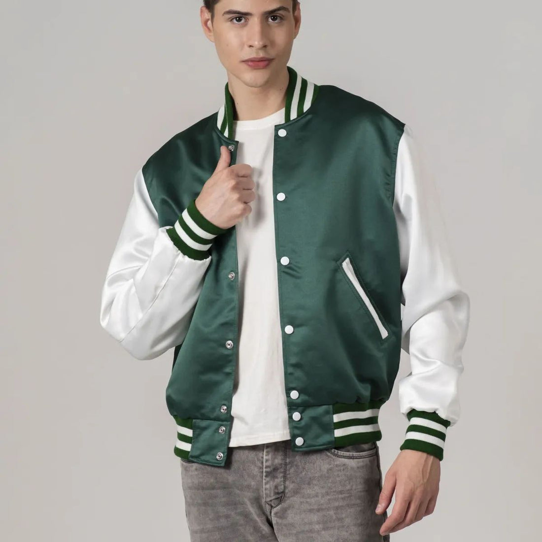 A male model wearing a Kelly green satin varsity jacket with white sleeves and a white collar, standing against a plain background.